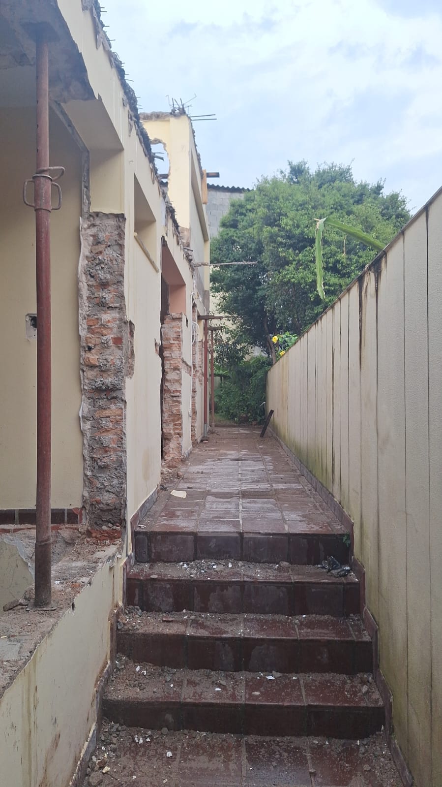 Passagem entre construções com paredes decapadas
